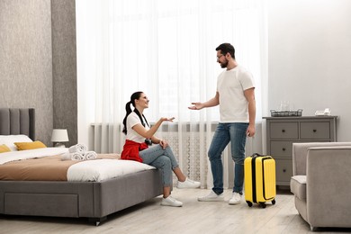 Photo of Happy travellers with suitcase in hotel room