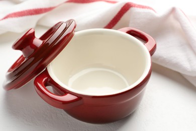 Photo of Ceramic casserole and lid on white table, closeup