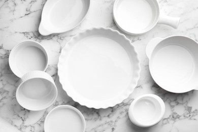 Photo of Different casseroles on white marble table, flat lay