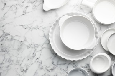 Photo of Different casseroles on white marble table, flat lay. Space for text