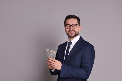 Photo of Portrait of banker with dollar banknotes on grey background, space for text