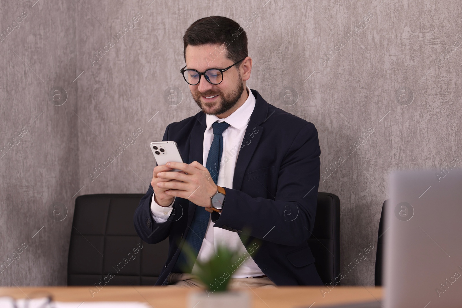 Photo of Portrait of banker using smartphone in office