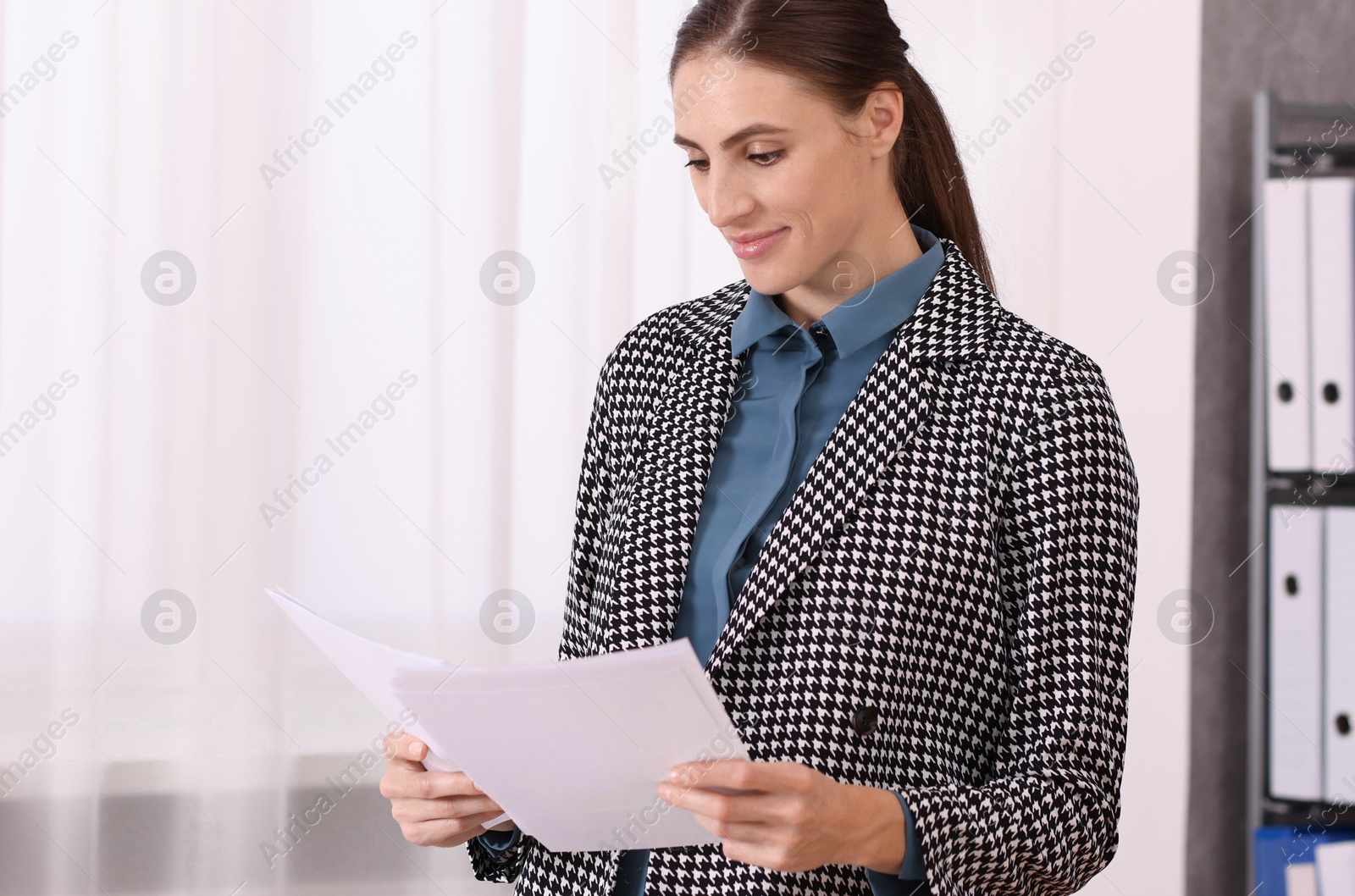 Photo of Banker with documents near table in office