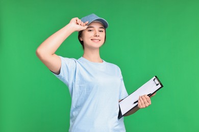 Photo of Girl in uniform with clipboard on green background. Work for teenagers