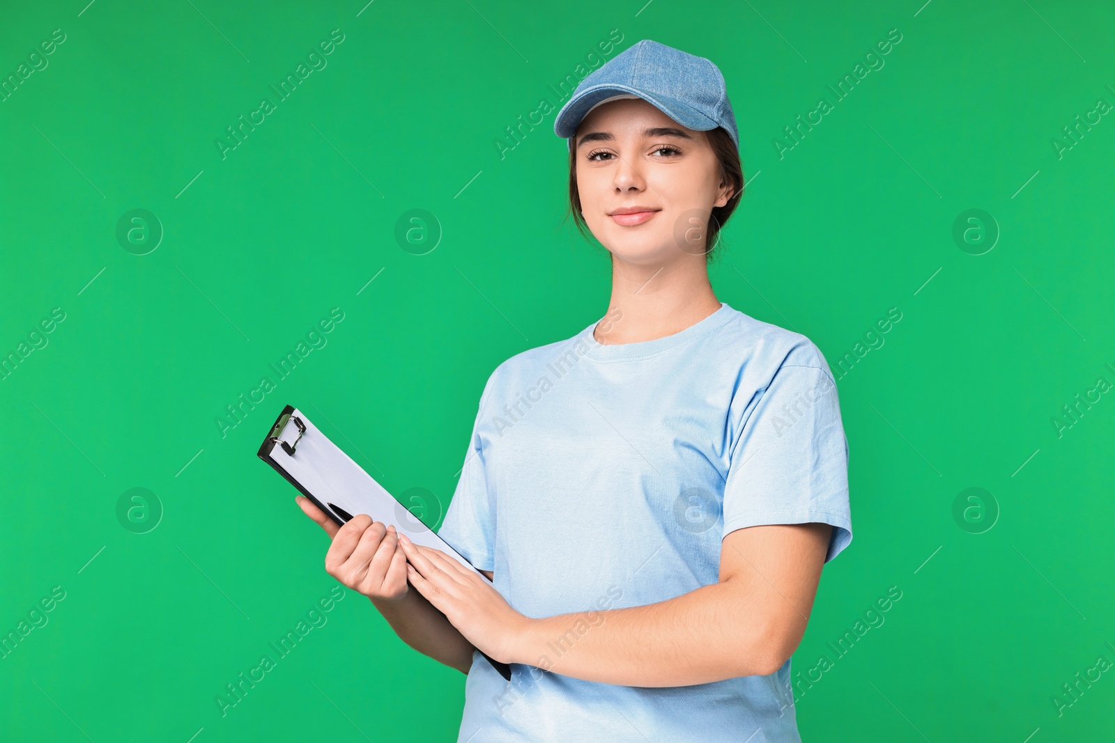 Photo of Girl in uniform with clipboard on green background. Work for teenagers