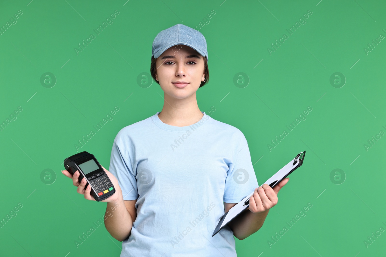 Photo of Girl in uniform with clipboard and payment terminal on green background. Work for teenagers