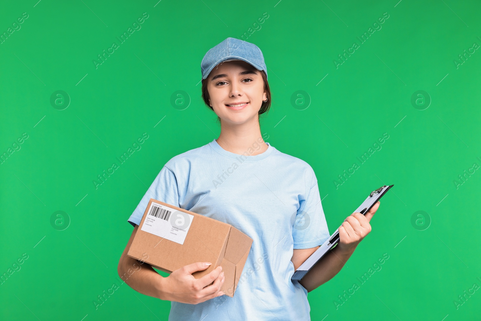 Photo of Girl in uniform with parcel and clipboard on green background. Work for teenagers