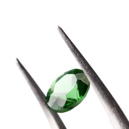 Photo of Tweezers with shiny green gemstone isolated on white