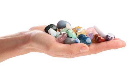 Photo of Woman holding different natural mineral stones on white background, closeup