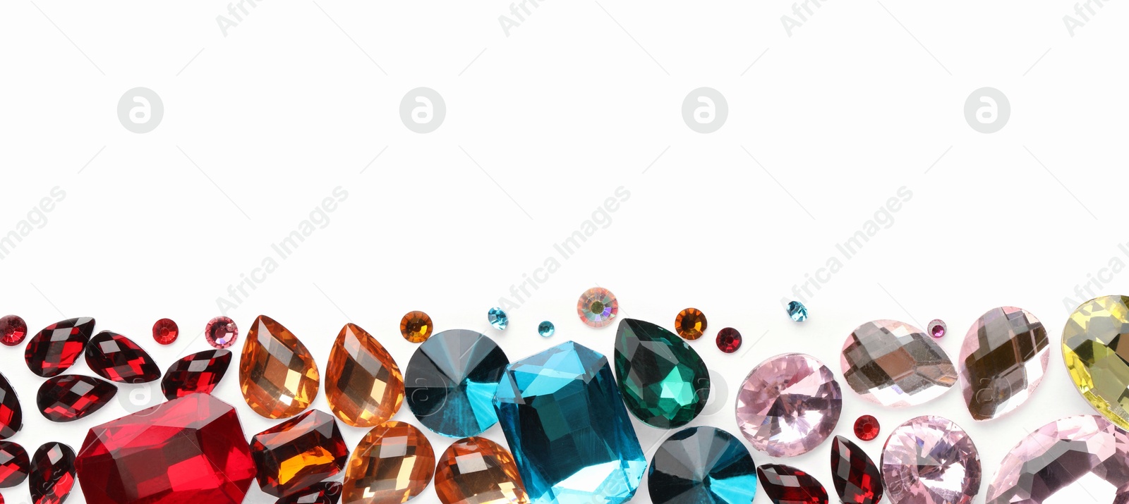 Photo of Different shiny gemstones on white background, flat lay. Space for text