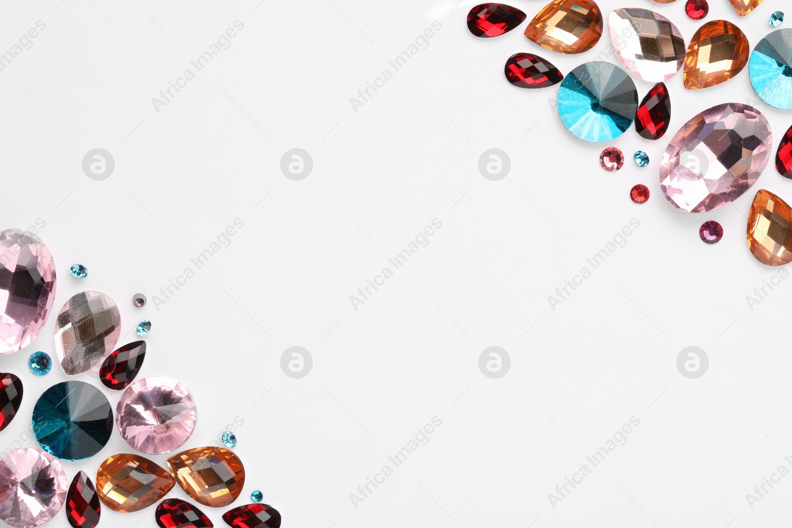 Photo of Different shiny gemstones on white background, flat lay. Space for text