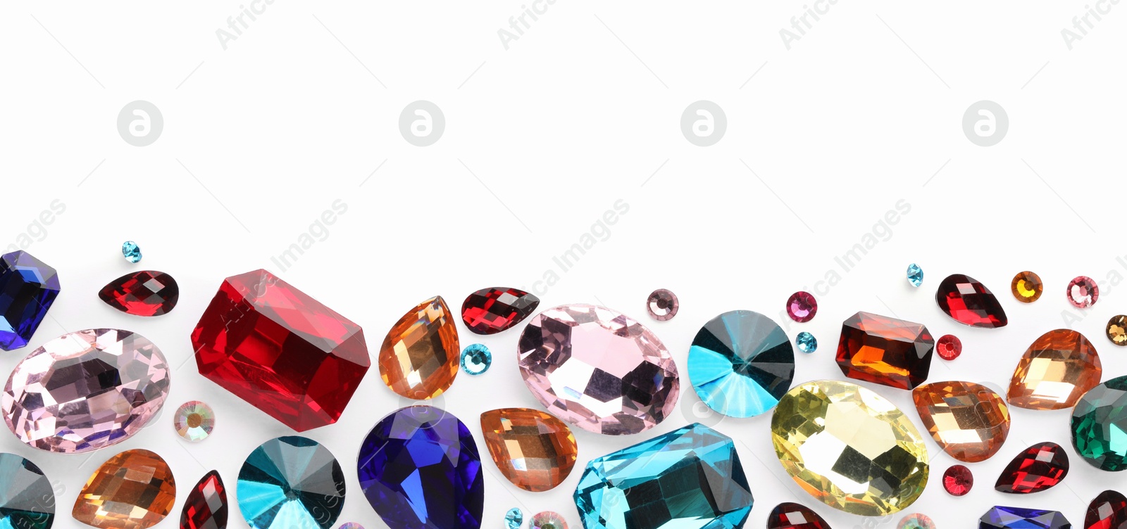 Photo of Different shiny gemstones on white background, flat lay. Space for text