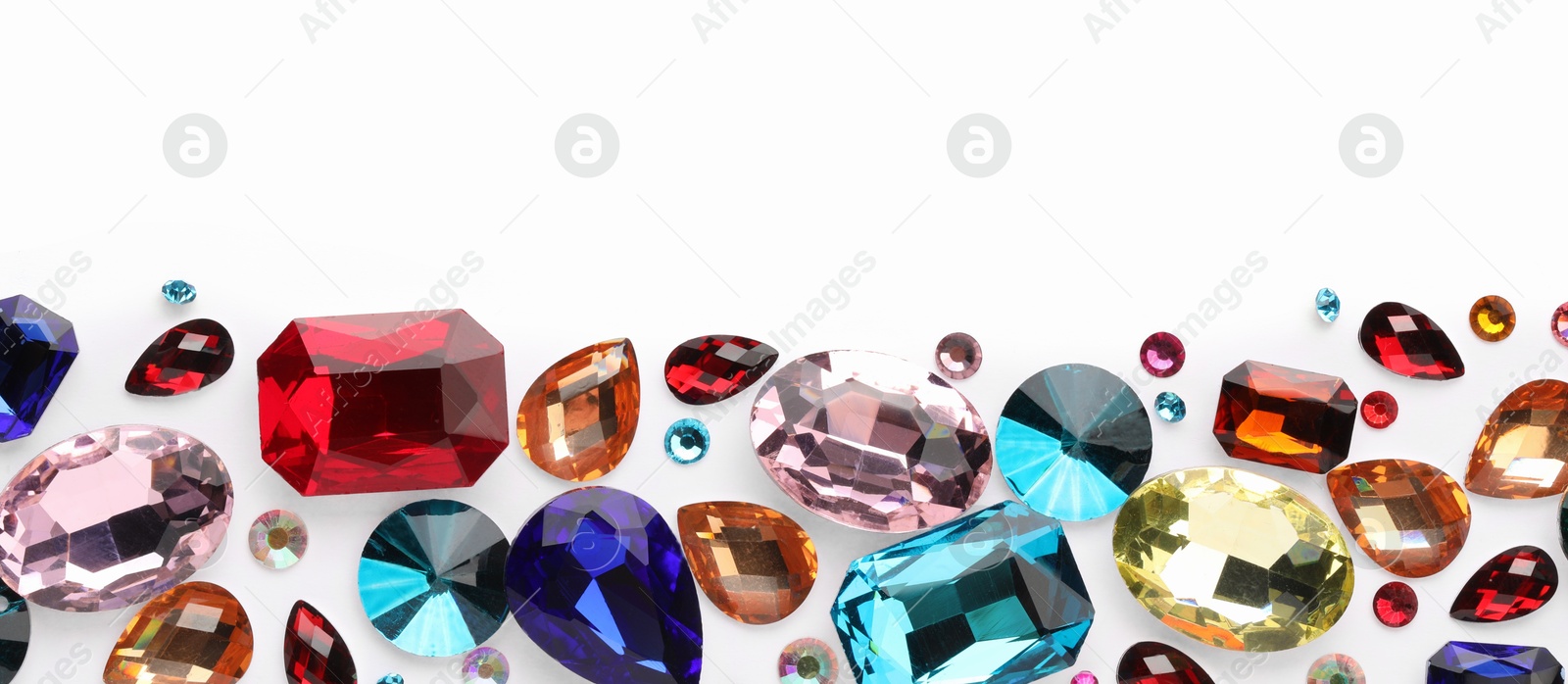 Photo of Different shiny gemstones on white background, flat lay. Space for text