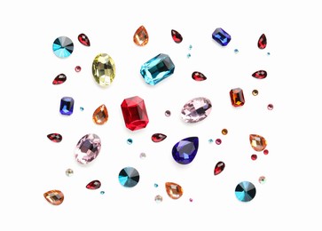 Photo of Different shiny gemstones on white background, flat lay