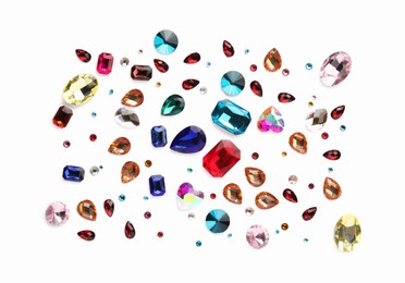 Photo of Different shiny gemstones on white background, flat lay