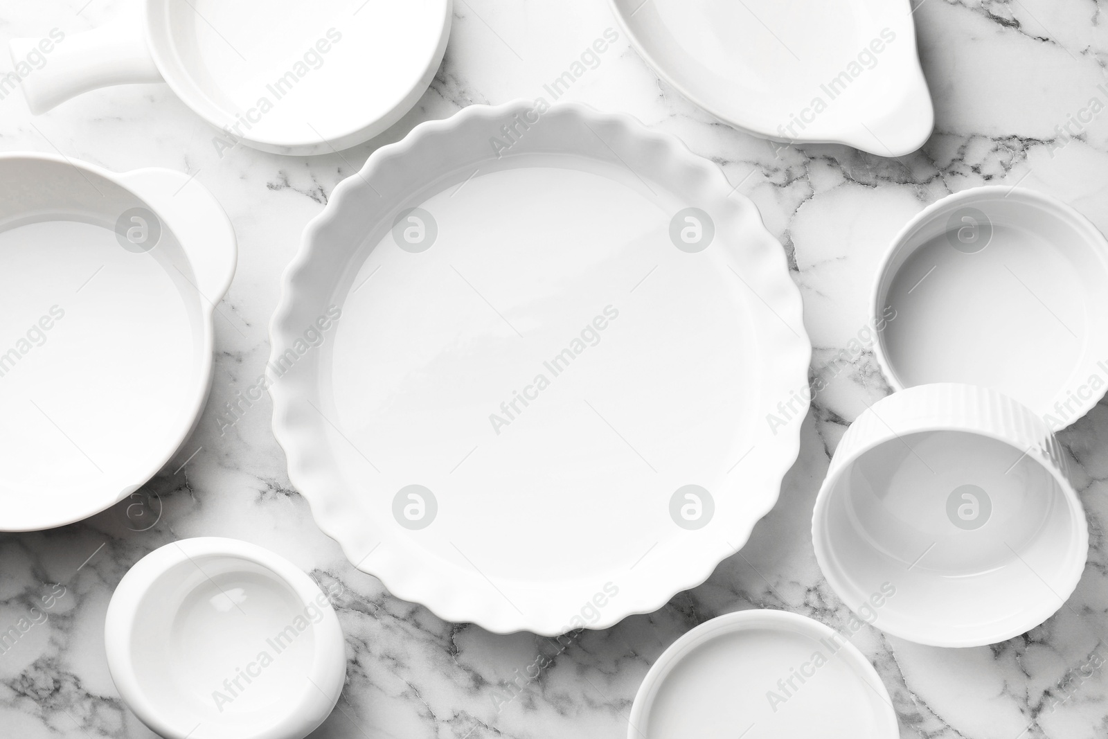 Photo of Different casseroles on white marble table, flat lay