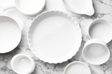 Photo of Different casseroles on white marble table, flat lay