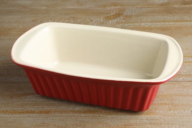 Photo of One ceramic casserole on wooden table, closeup