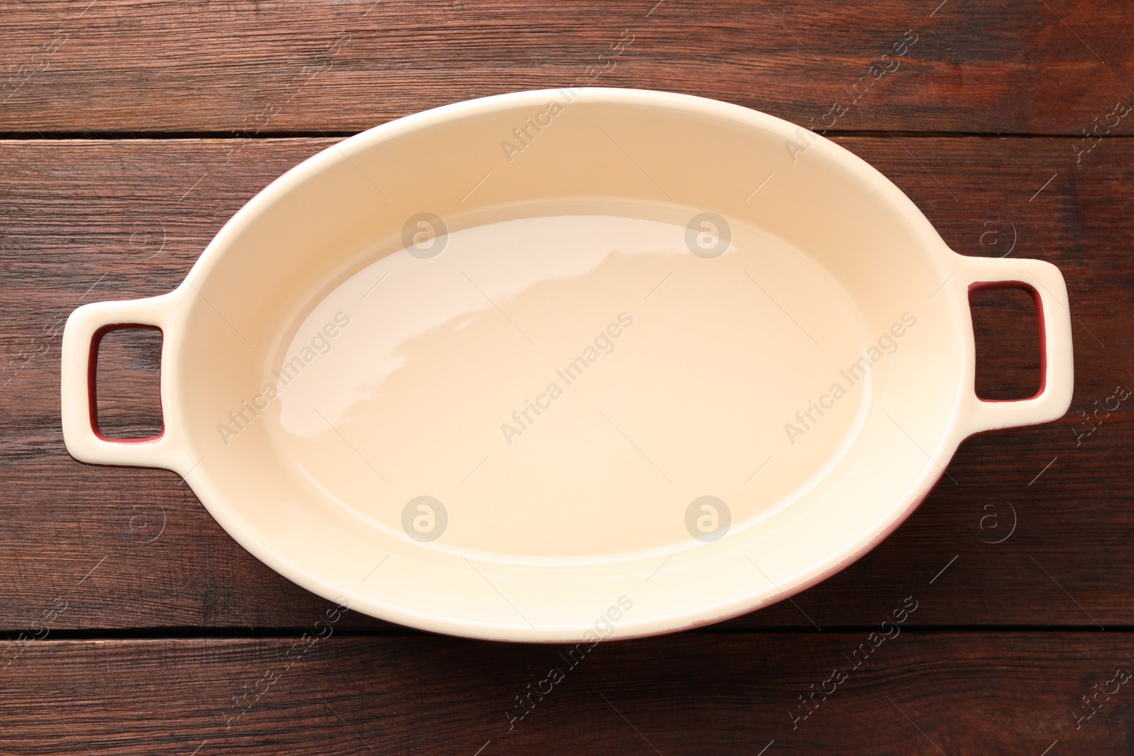 Photo of One ceramic casserole on wooden table, top view