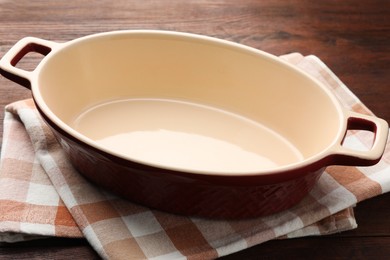 Photo of One ceramic casserole on wooden table, closeup