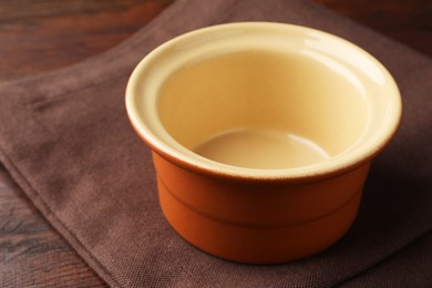 Photo of One ceramic casserole on wooden table, closeup