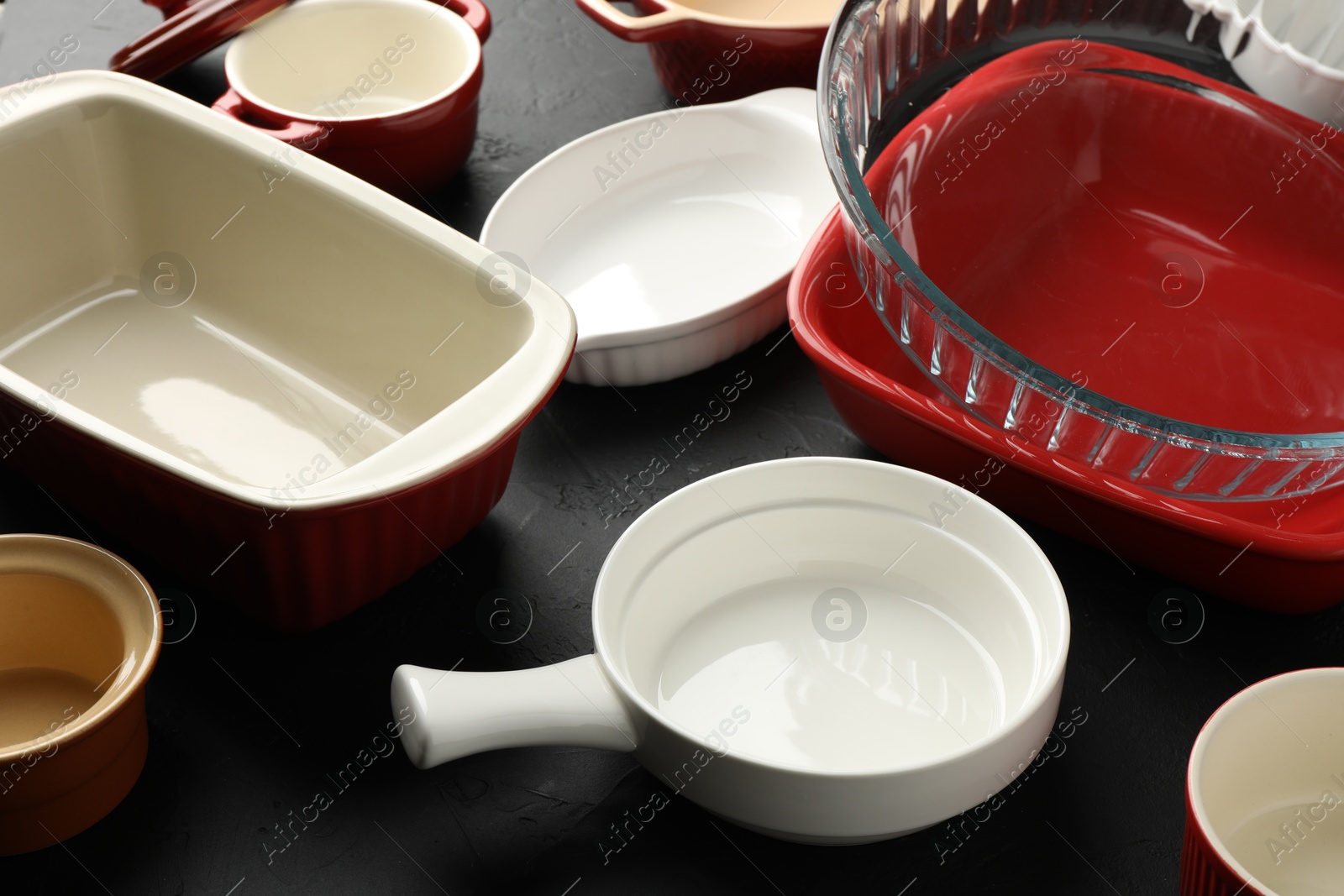 Photo of Many different casseroles on black table, closeup