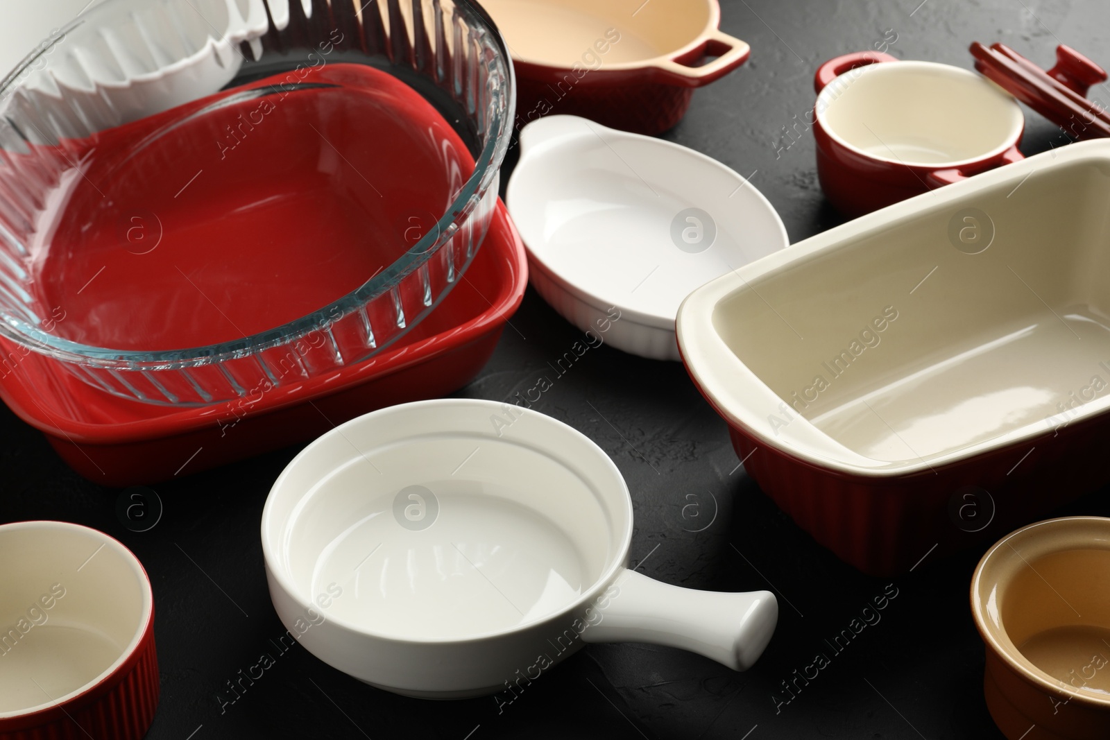 Photo of Many different casseroles on black table, closeup