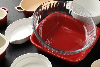 Photo of Many different casseroles on black table, closeup