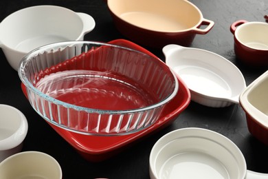 Photo of Many different casseroles on black table, closeup