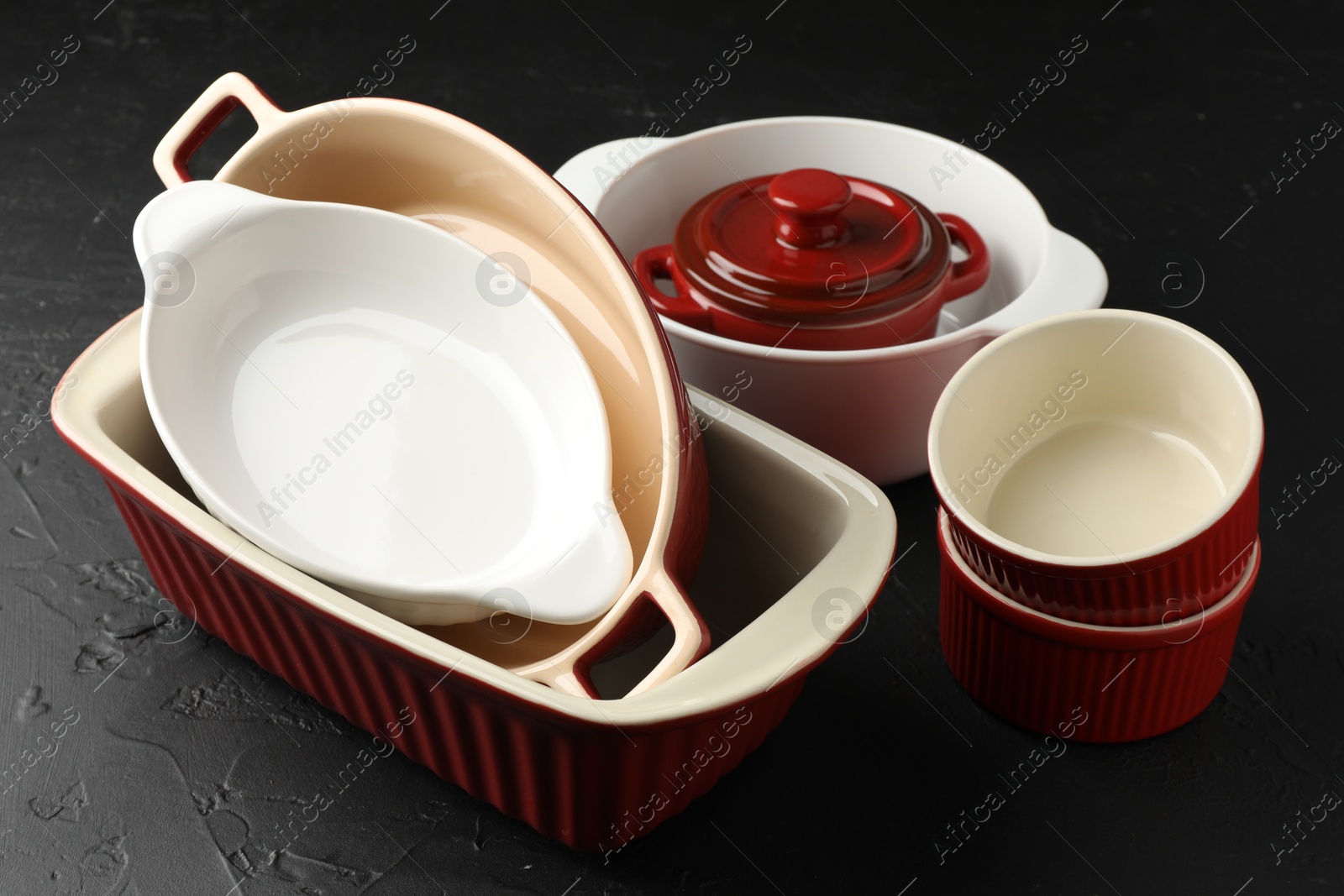 Photo of Many different casseroles on black table, closeup