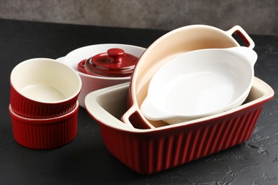 Photo of Many different casseroles on black table, closeup