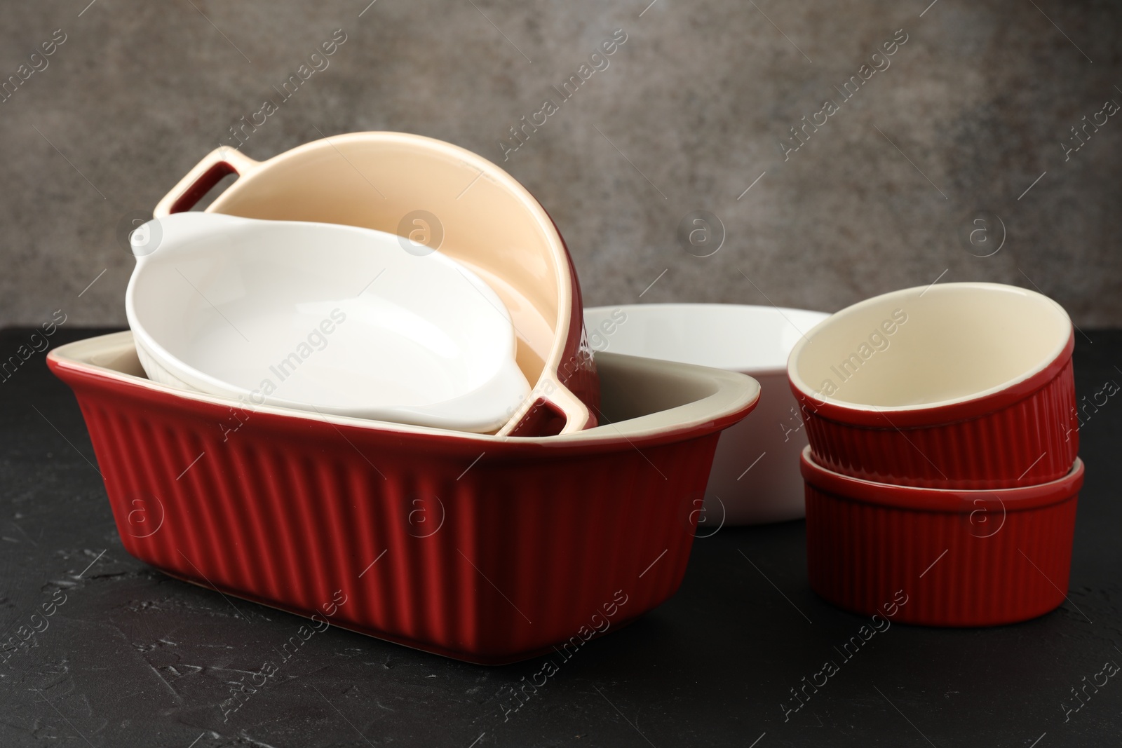 Photo of Many different casseroles on black table, closeup