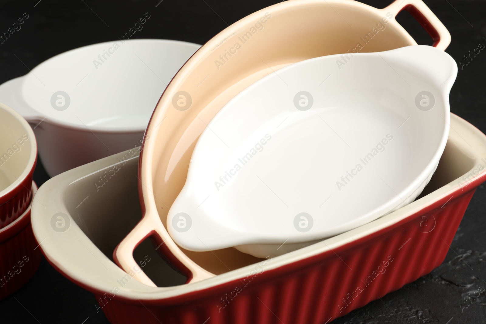 Photo of Many different casseroles on black table, closeup