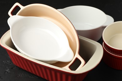 Photo of Many different casseroles on black table, closeup