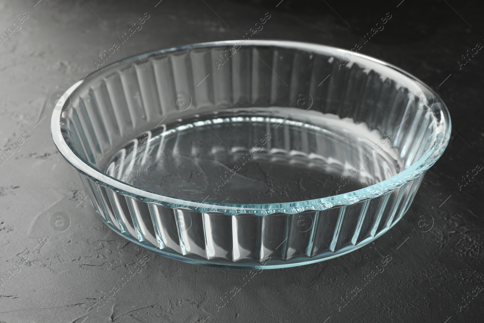 Photo of One glass casserole on black table, closeup