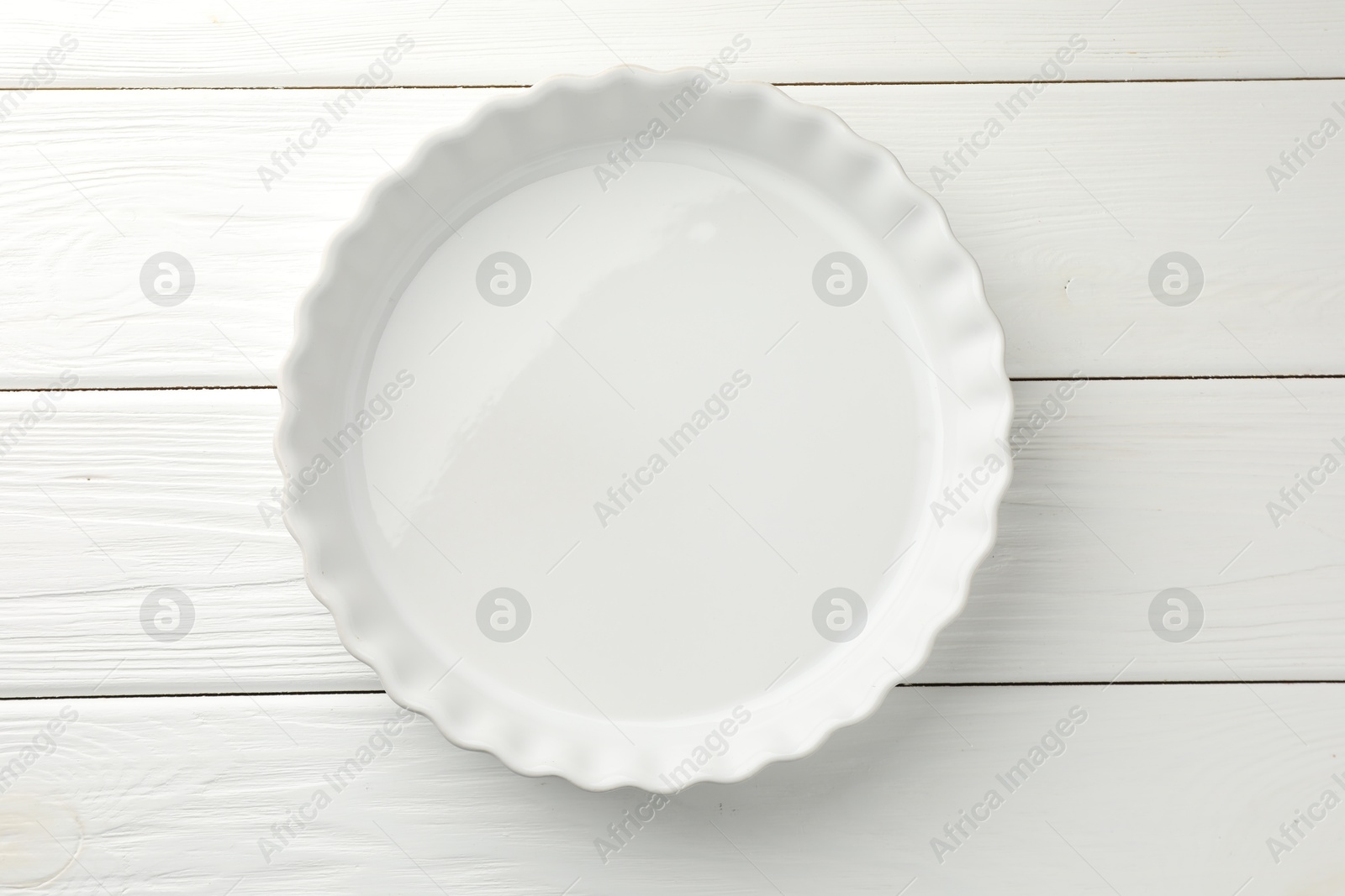 Photo of One ceramic casserole on white wooden table, top view