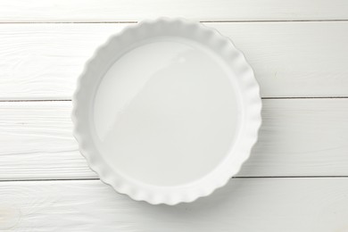 Photo of One ceramic casserole on white wooden table, top view