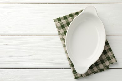 Photo of One ceramic casserole on white wooden table, top view. Space for text