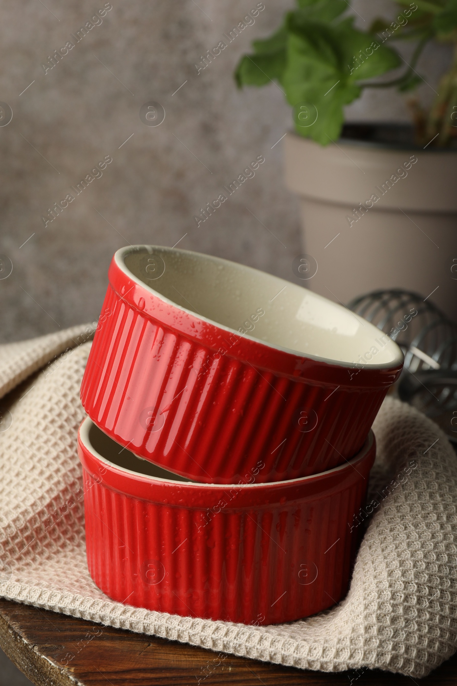 Photo of Red ceramic casseroles on wooden table, closeup