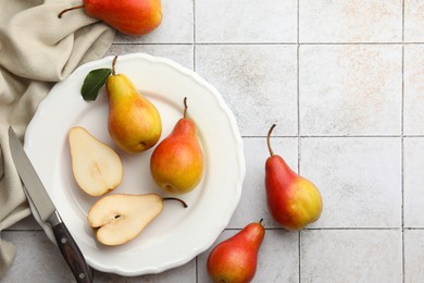 Photo of Ripe juicy pears on light tiled table, flat lay. Space for text