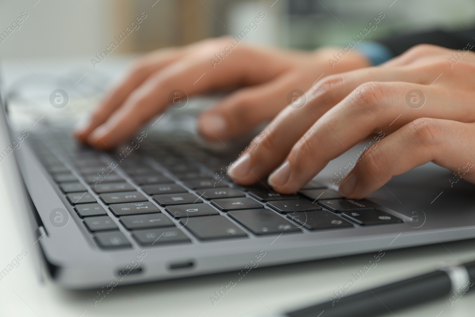 Photo of Businesswoman using laptop at table indoors, closeup. Modern technology