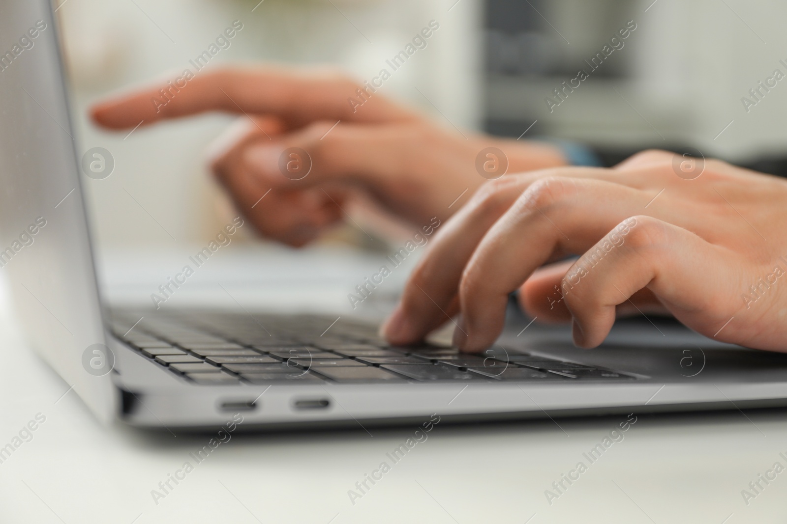 Photo of Businesswoman using laptop at table indoors, closeup. Modern technology