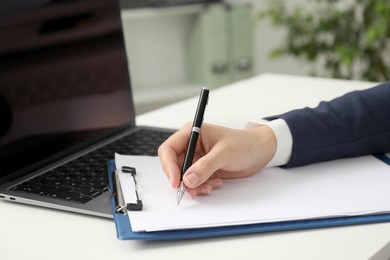 Photo of Businesswoman working at white table indoors, closeup view