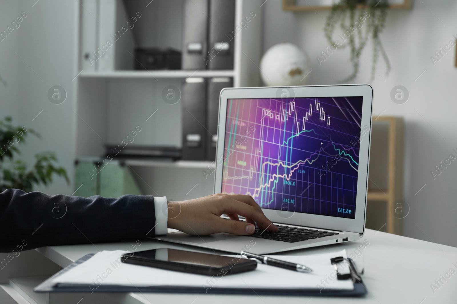 Photo of Businesswoman using laptop at white table indoors, closeup. Modern technology