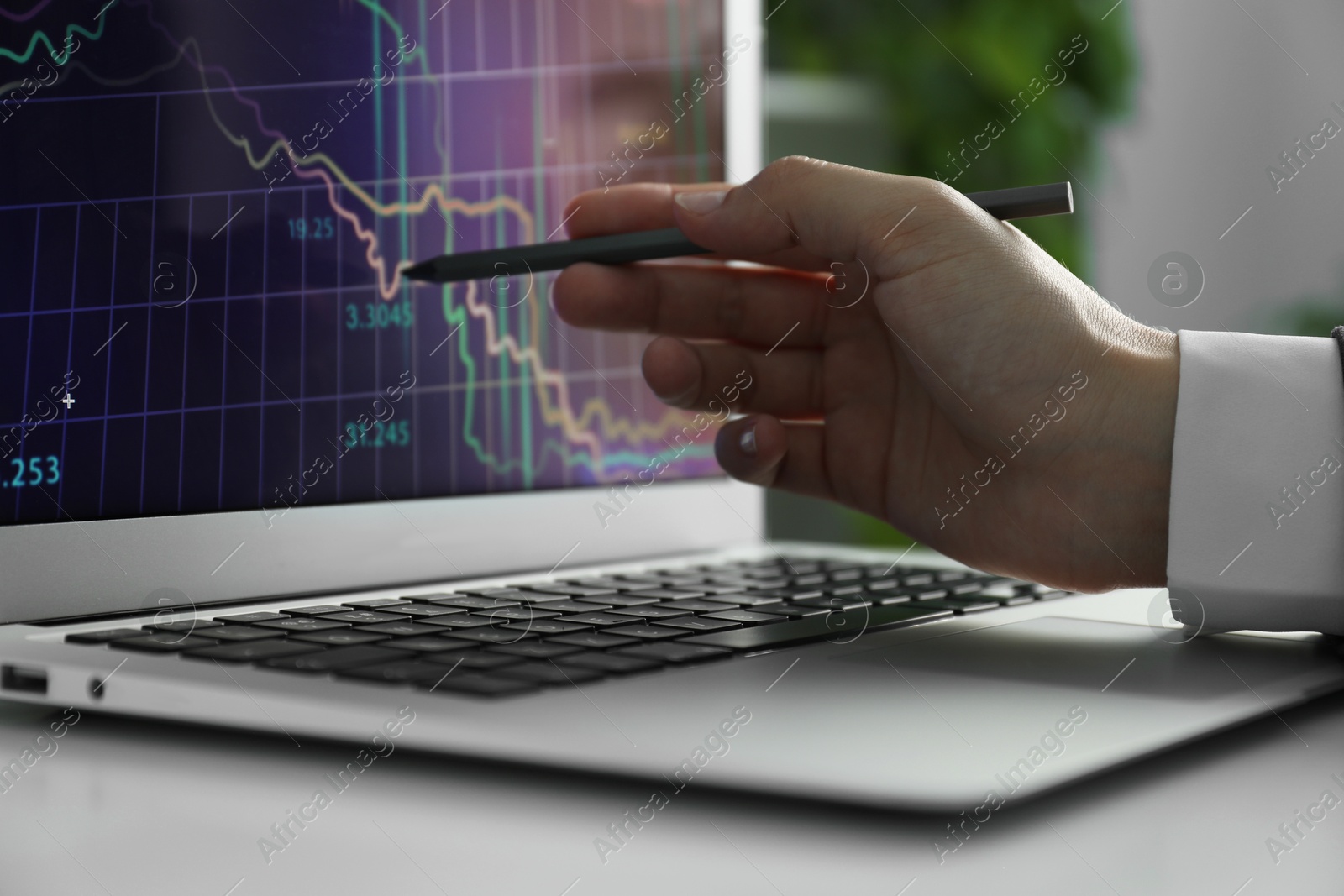 Photo of Businesswoman using laptop at white table indoors, closeup. Modern technology