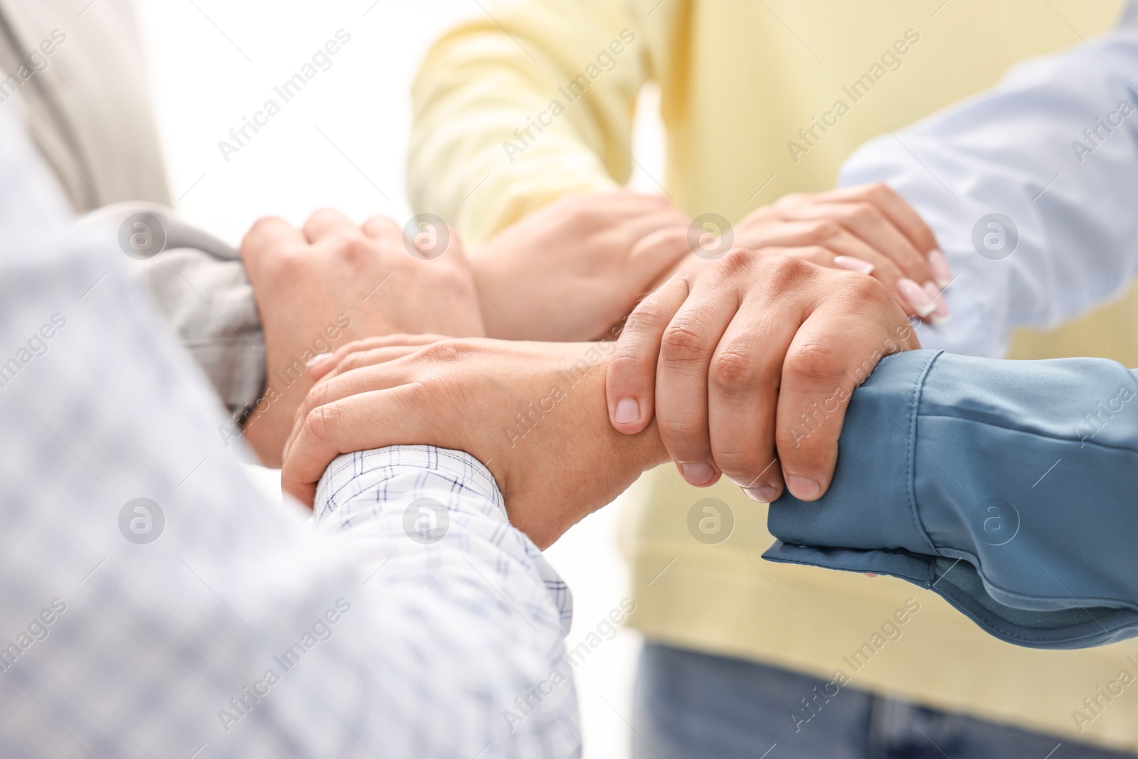 Photo of Teamwork. Group of employees joining hands in office, closeup