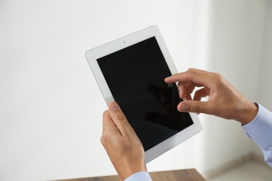 Photo of Businessman using tablet in office, closeup. Modern technology