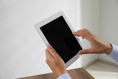 Photo of Businessman using tablet in office, closeup. Modern technology