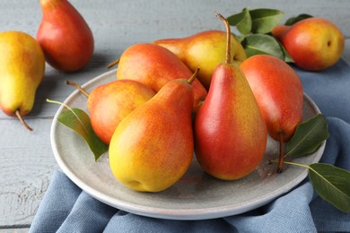 Photo of Ripe juicy pears on grey wooden table, closeup