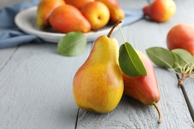 Photo of Ripe juicy pears on grey wooden table, closeup